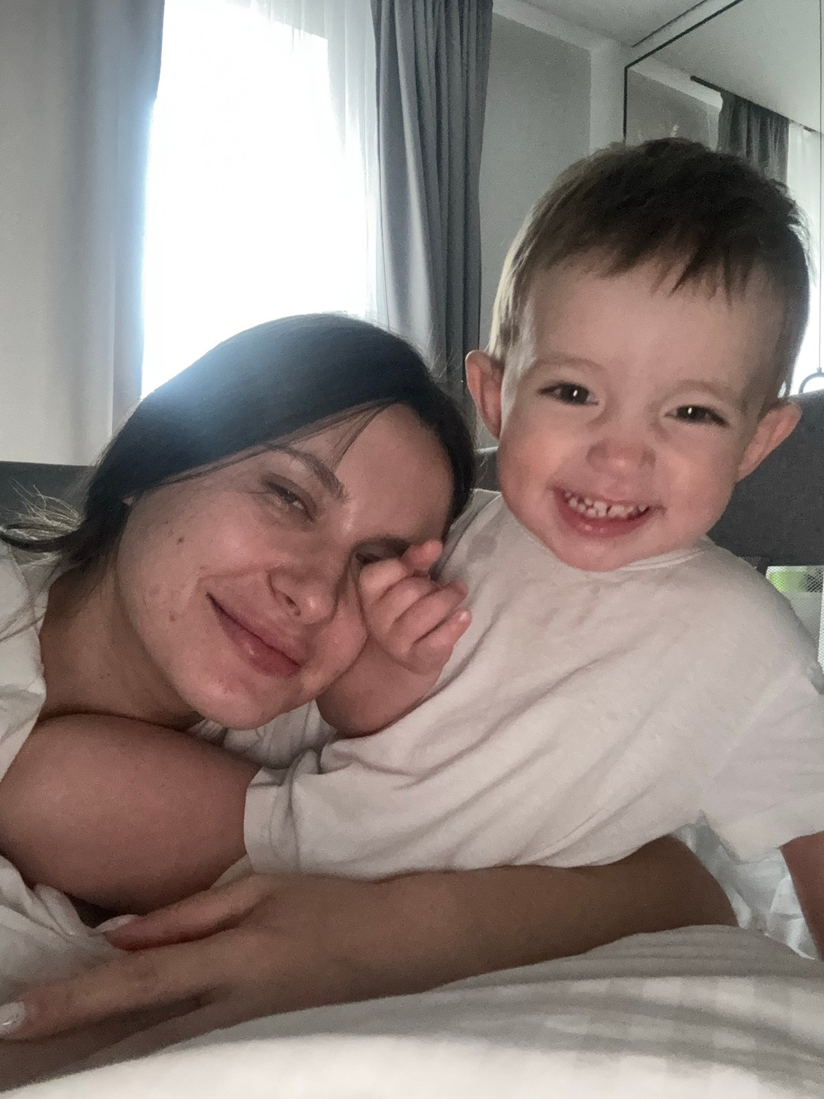 Woman and smiling child photographed together indoors