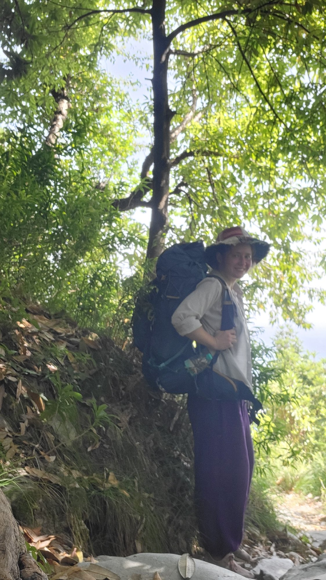 Young person with backpack observed standing outdoors in Haini