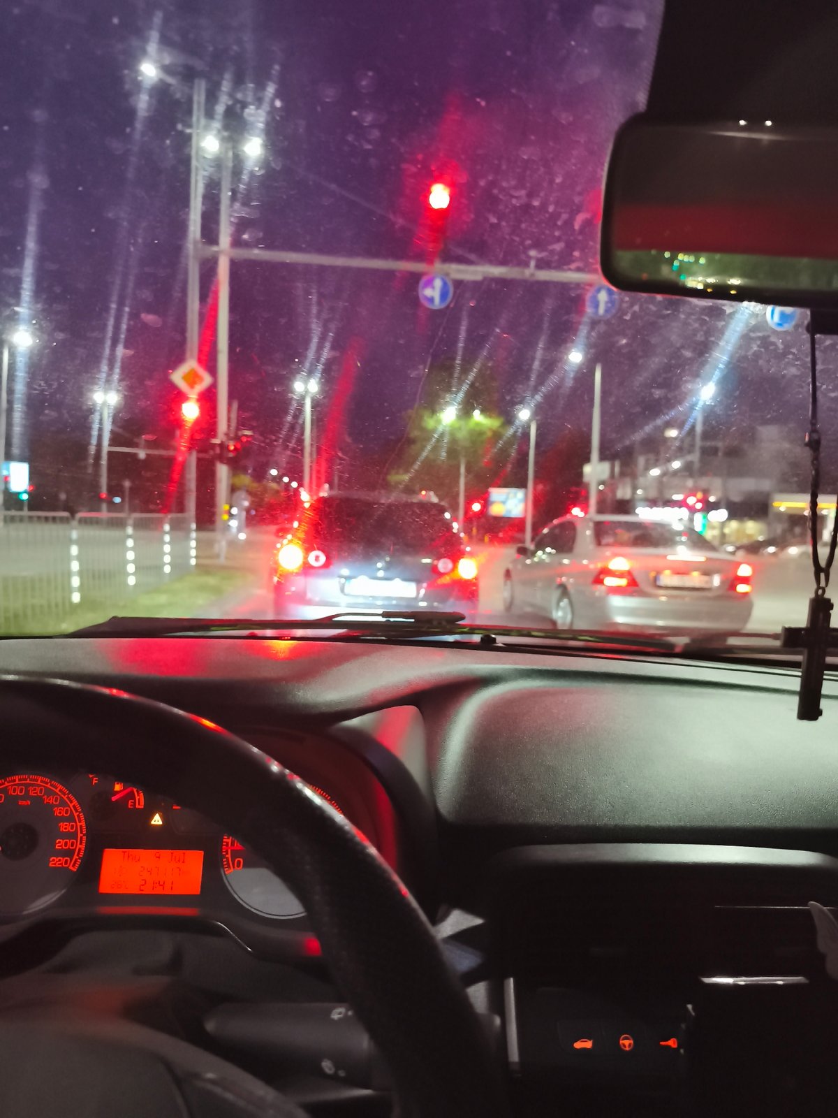 Night drive through Plovdiv, stopped at a rain-slicked intersection
