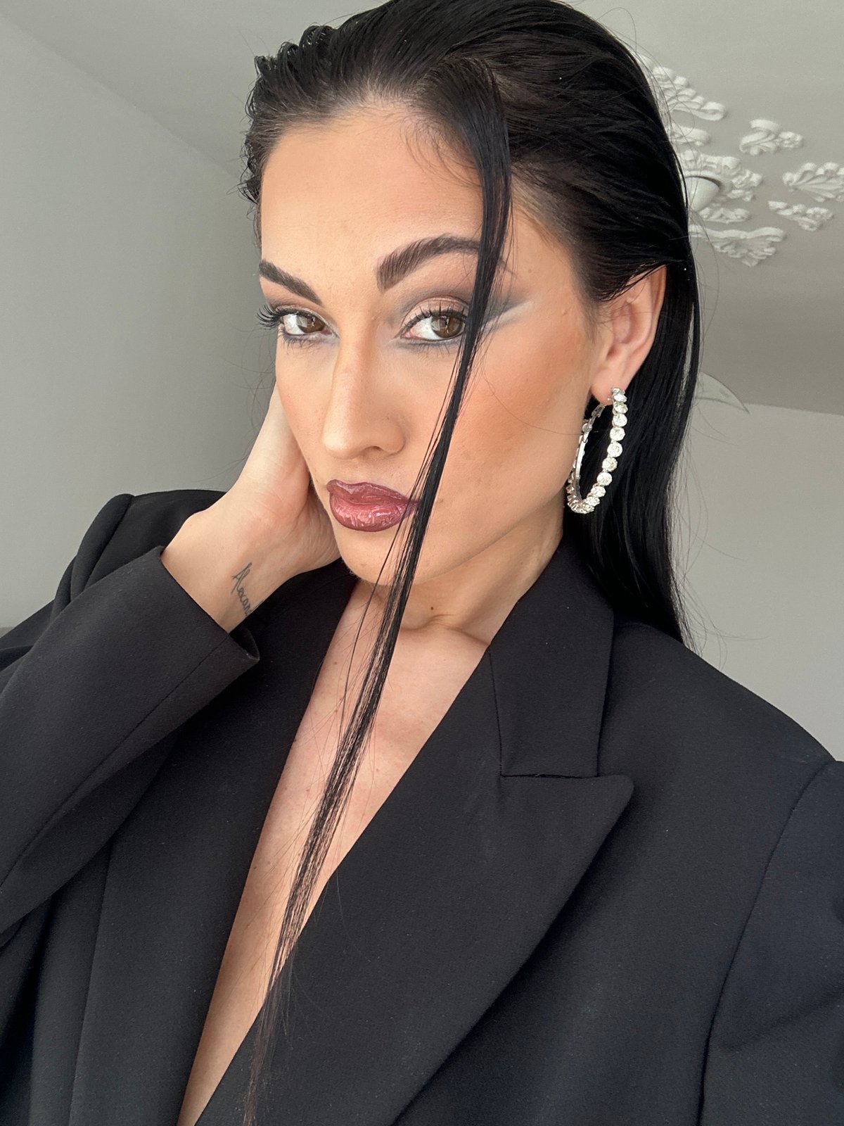 Portrait session captures woman in black blazer, tilted pose