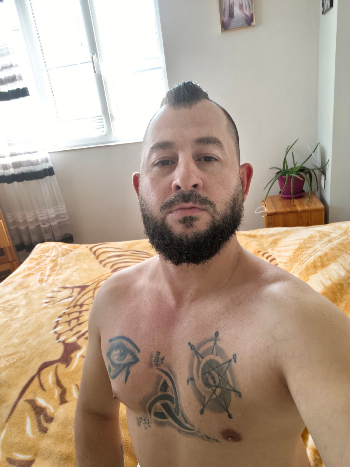 Bearded man photographed shirtless in early morning selfie session