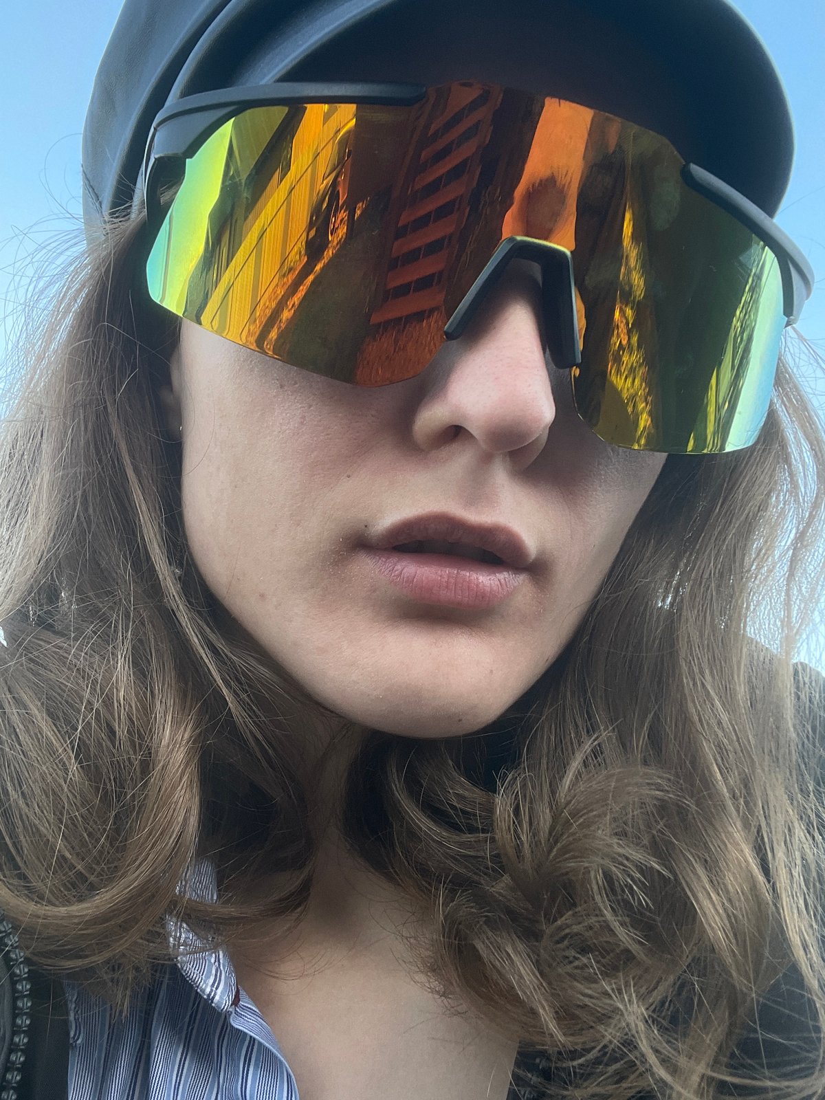 Person in gold sunglasses photographed at modern house in Russia