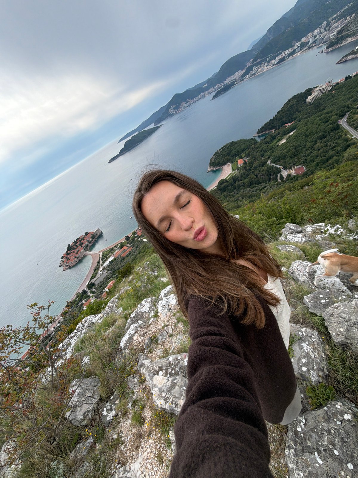 Woman takes selfie overlooking coastal Pržno, Montenegro