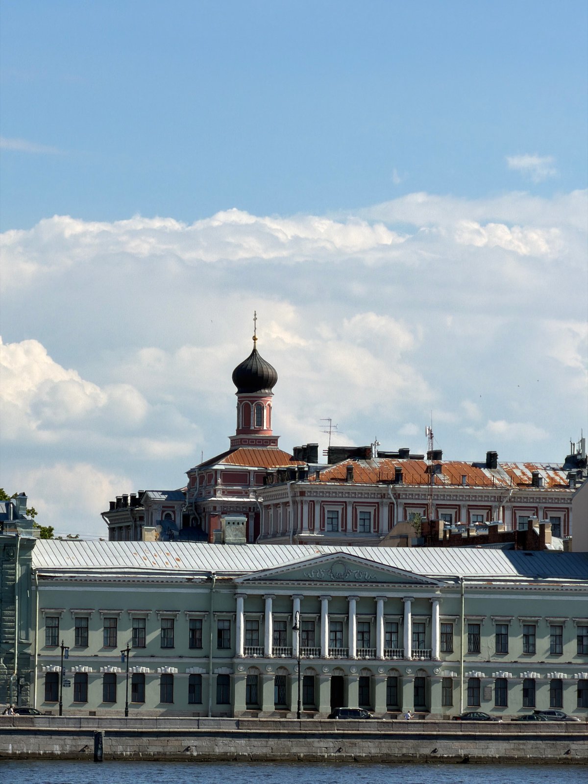 Tourist explores Saint Petersburg waterfront landmarks on sunny afternoon