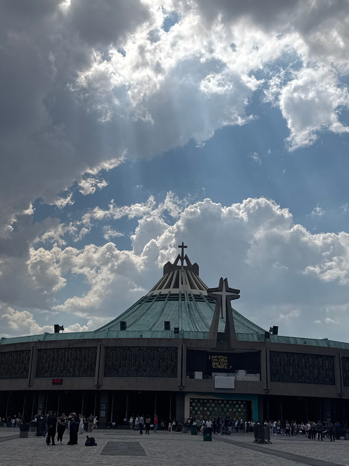 Evening gathering at modern basilica with distinctive architecture