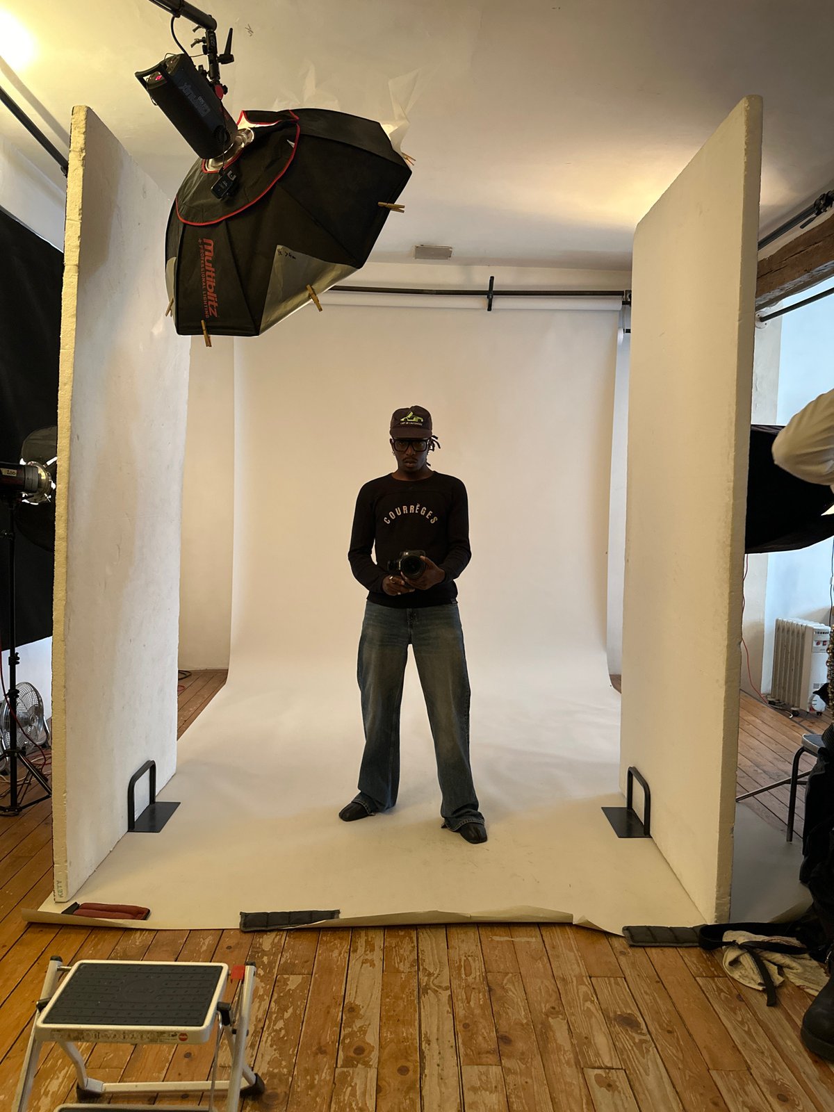 Man photographed in makeshift studio wearing Courrèges shirt, Paris