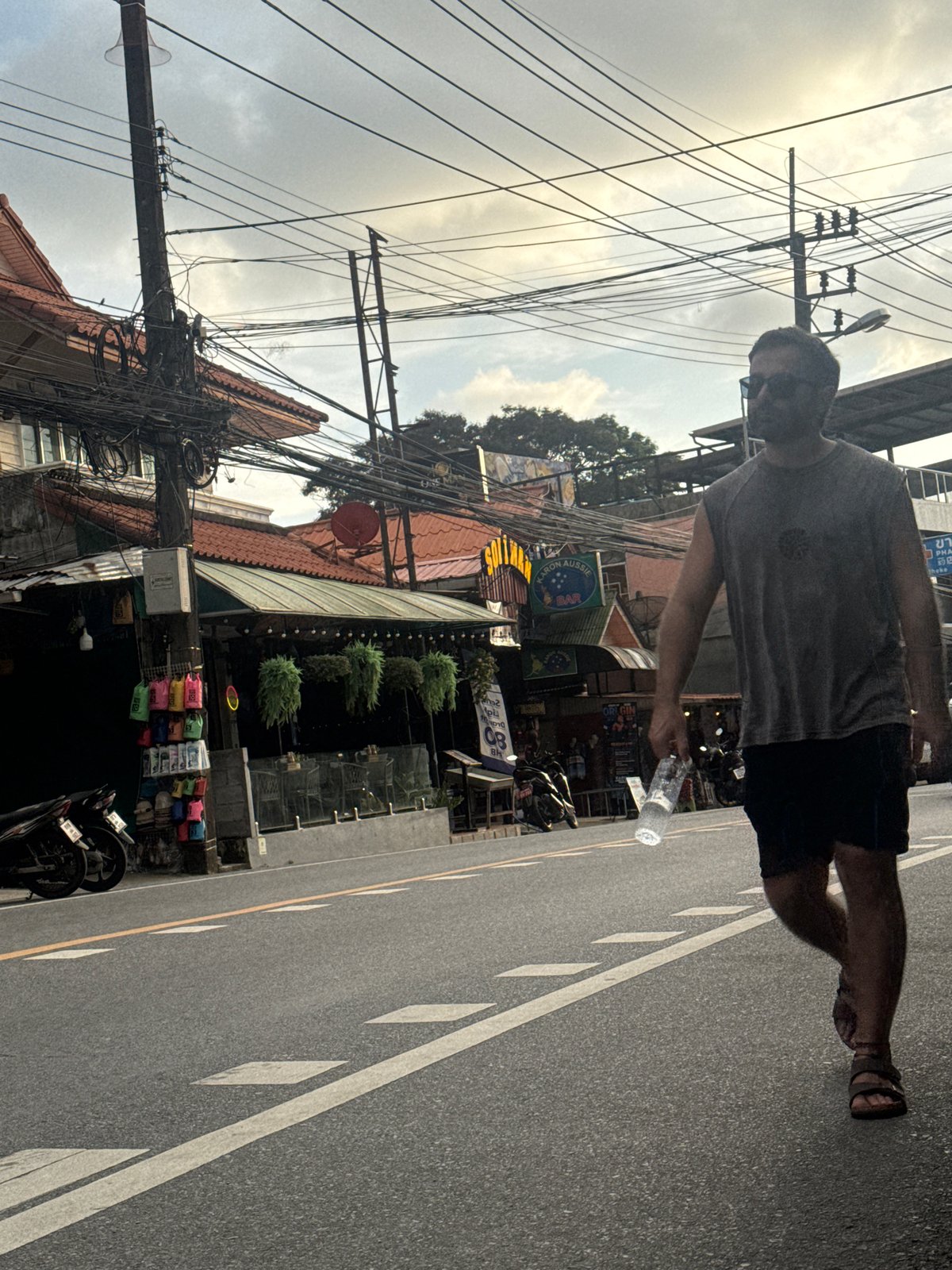 Karon street life: scooters, shops, and a Phuket parasail