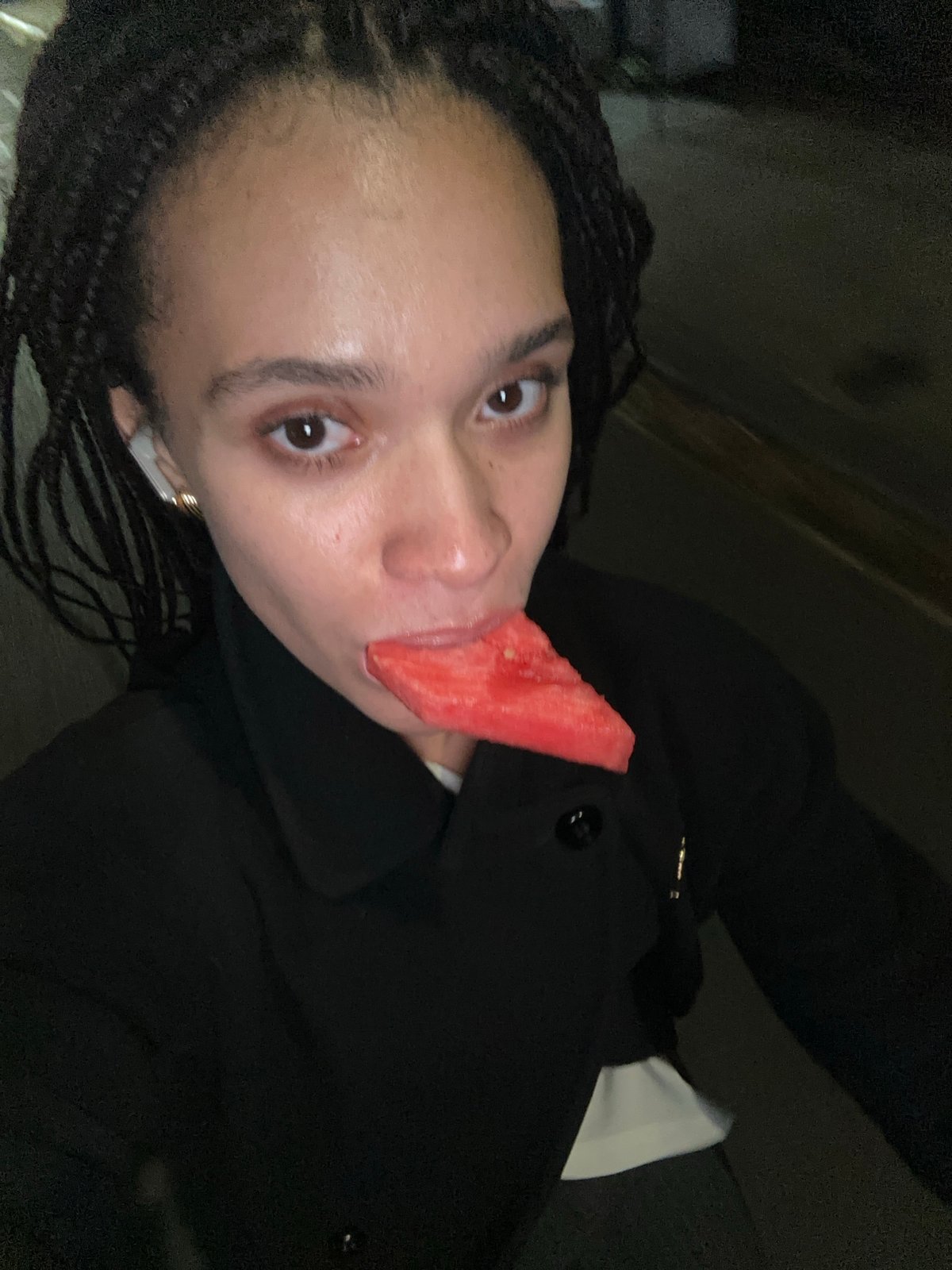 Person enjoys watermelon snack in London evening
