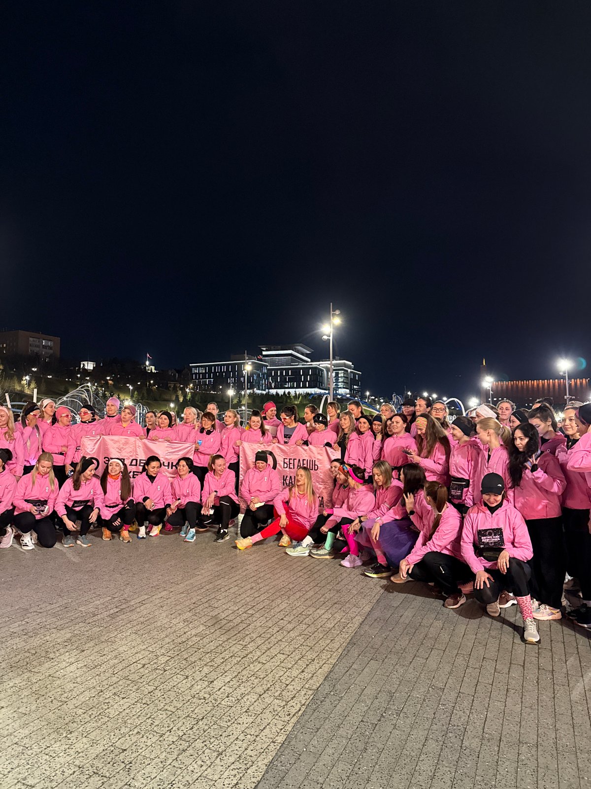 Pink-clad group poses with Cyrillic banner in Kazan