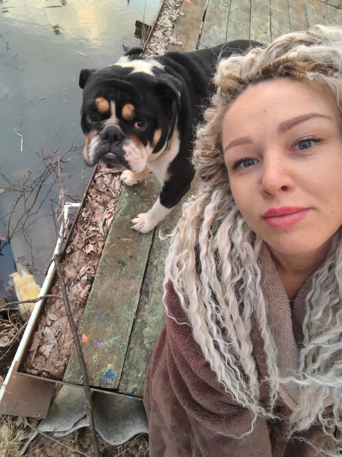 Woman and bulldog enjoy afternoon at Russian waterfront pier