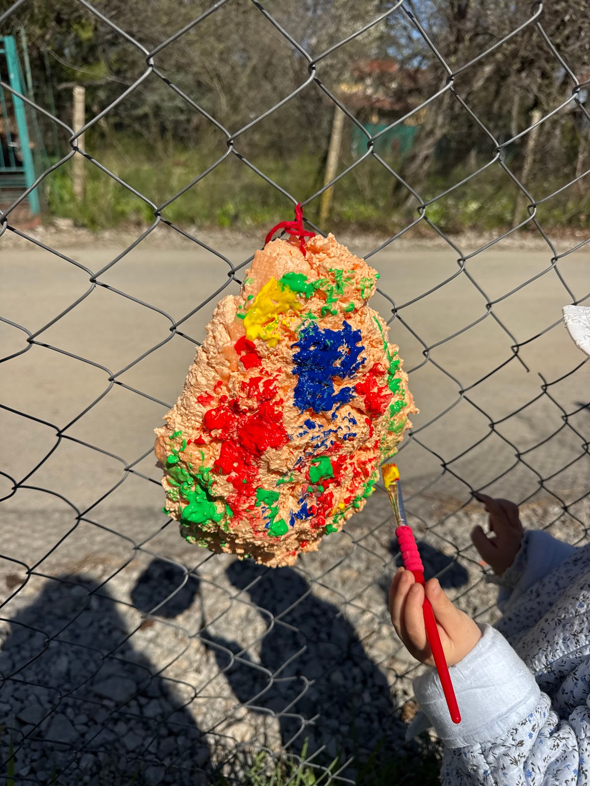 Child paints colorful artwork on fence in Sofia