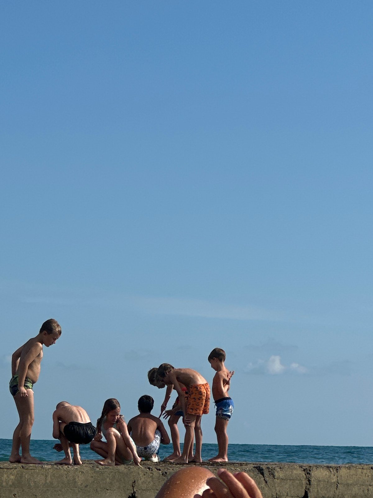 Kids on a seaside pier on a sunny summer day