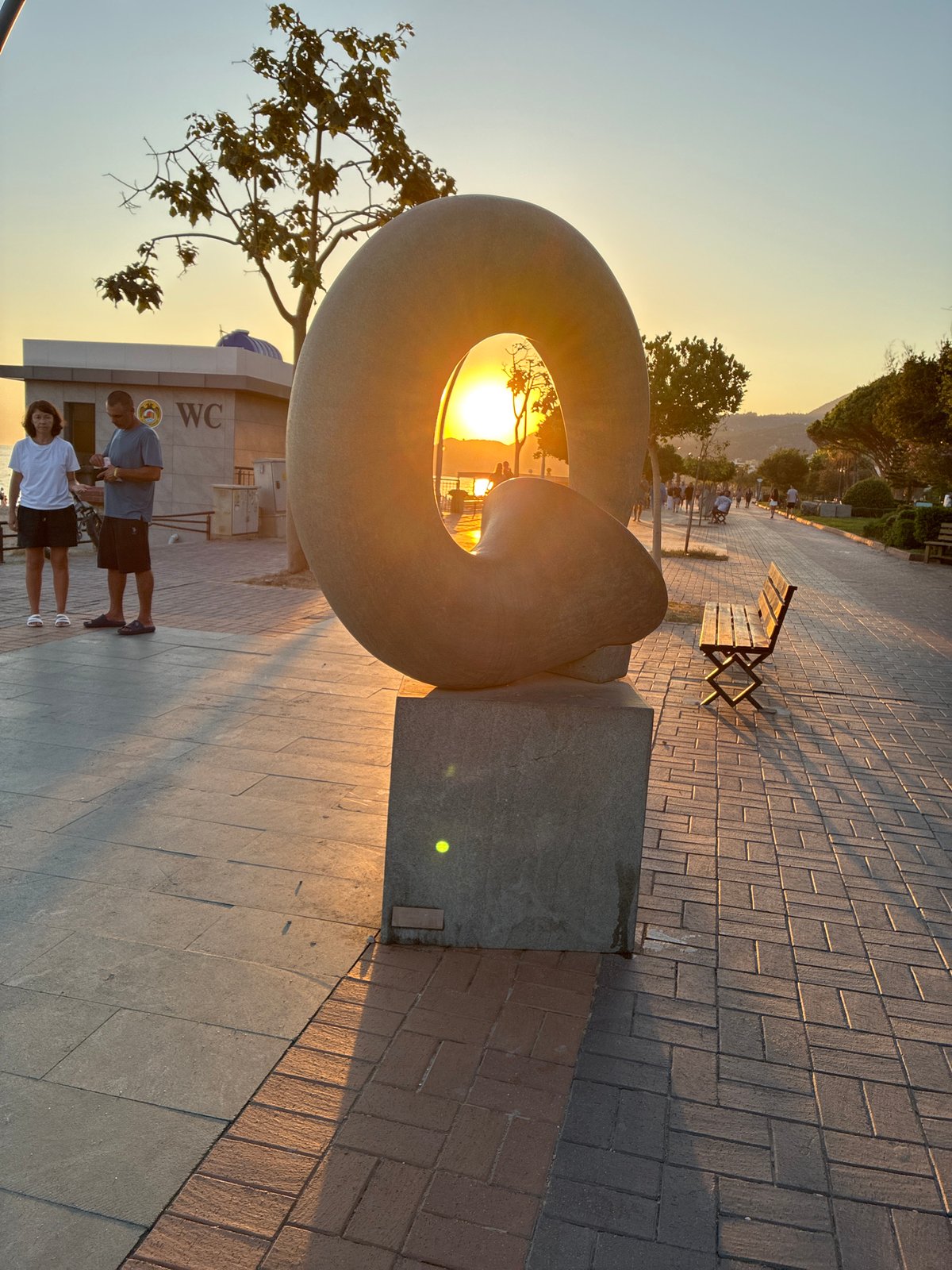 Sunset along Alanya's promenade, cats, sculptures, and beach crowds