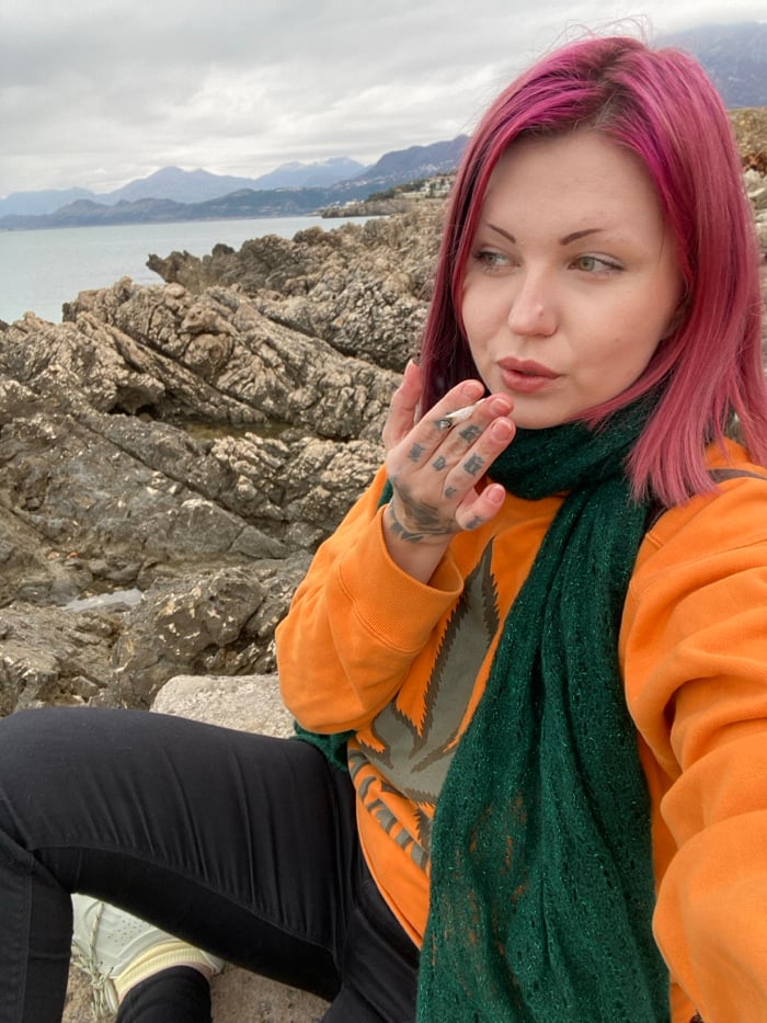 Pink-haired visitor contemplates Adriatic coastline in Bar, Montenegro
