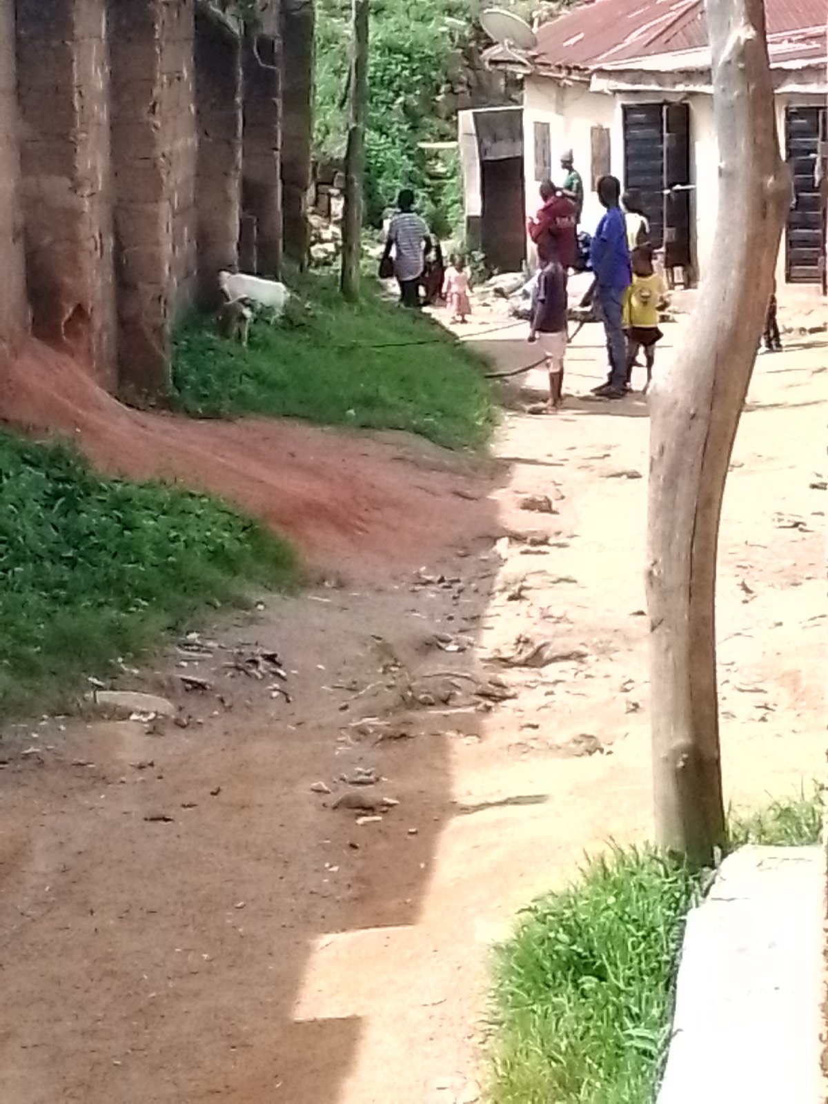 Kids play soccer and daily life moves through a dusty urban alley