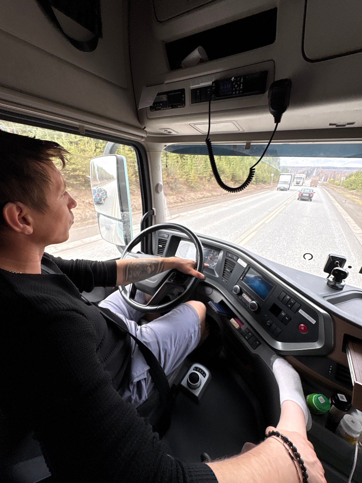 Truck driver travels paved road near Iiul'skoe, Russia