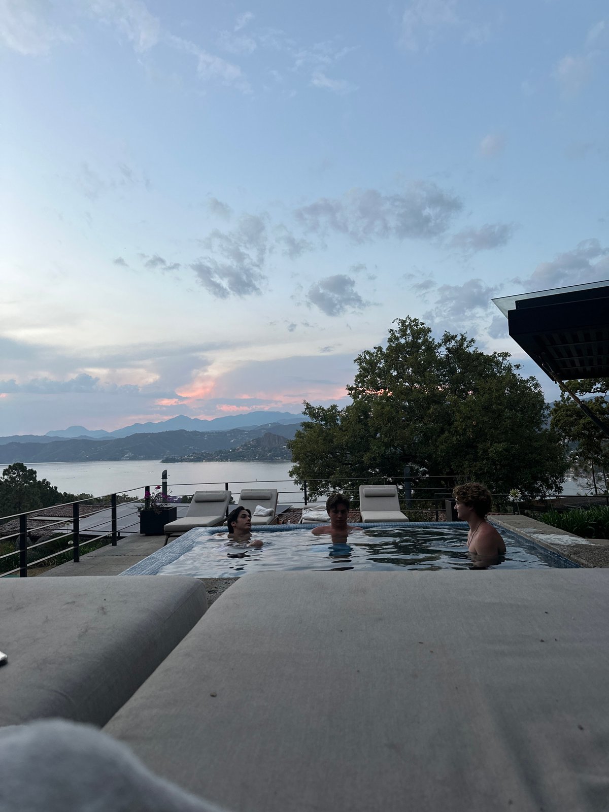 People swim at scenic mountain lake overlook during sunset