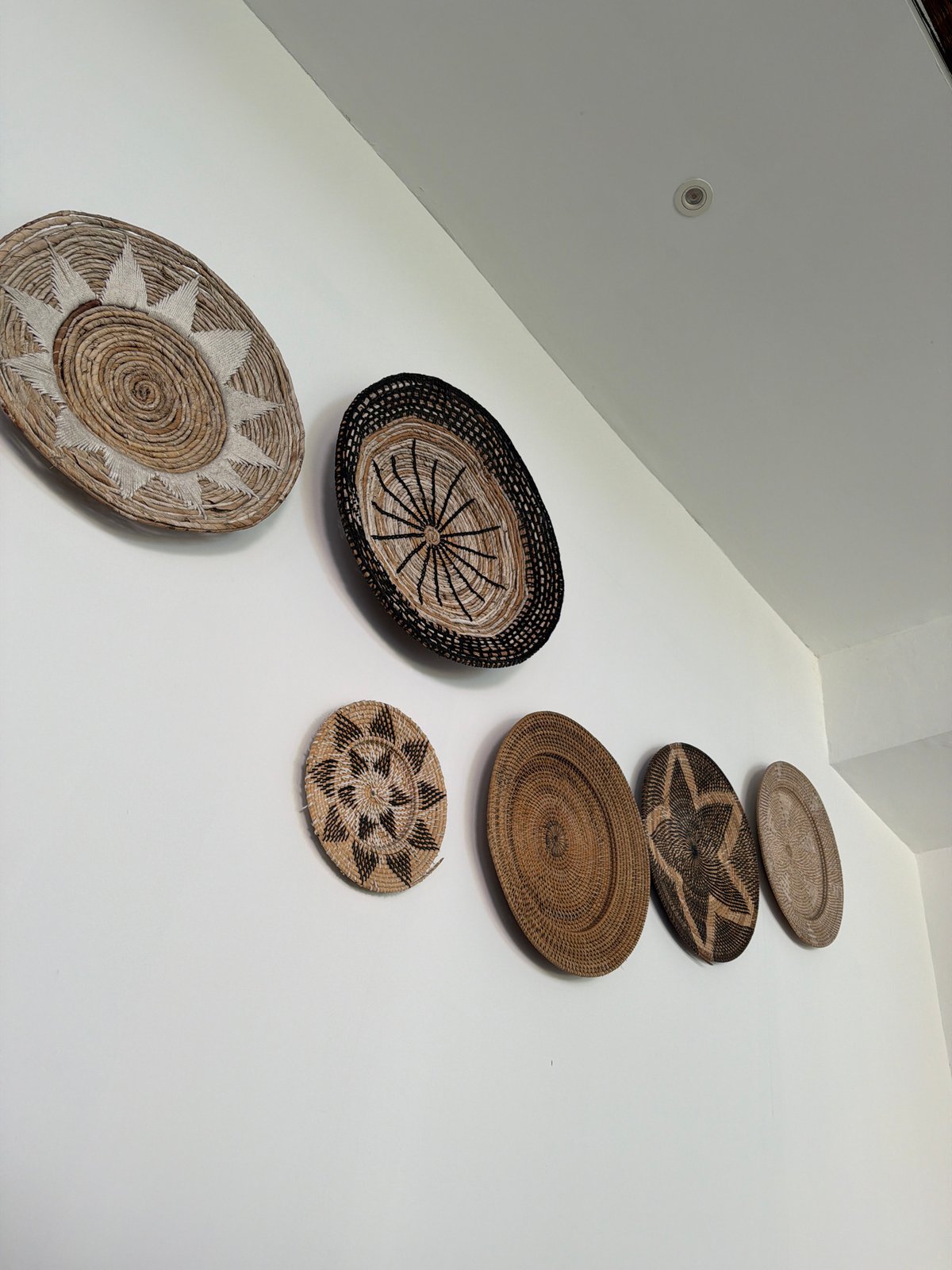 Decorative woven baskets displayed on indoor wall in Kuta