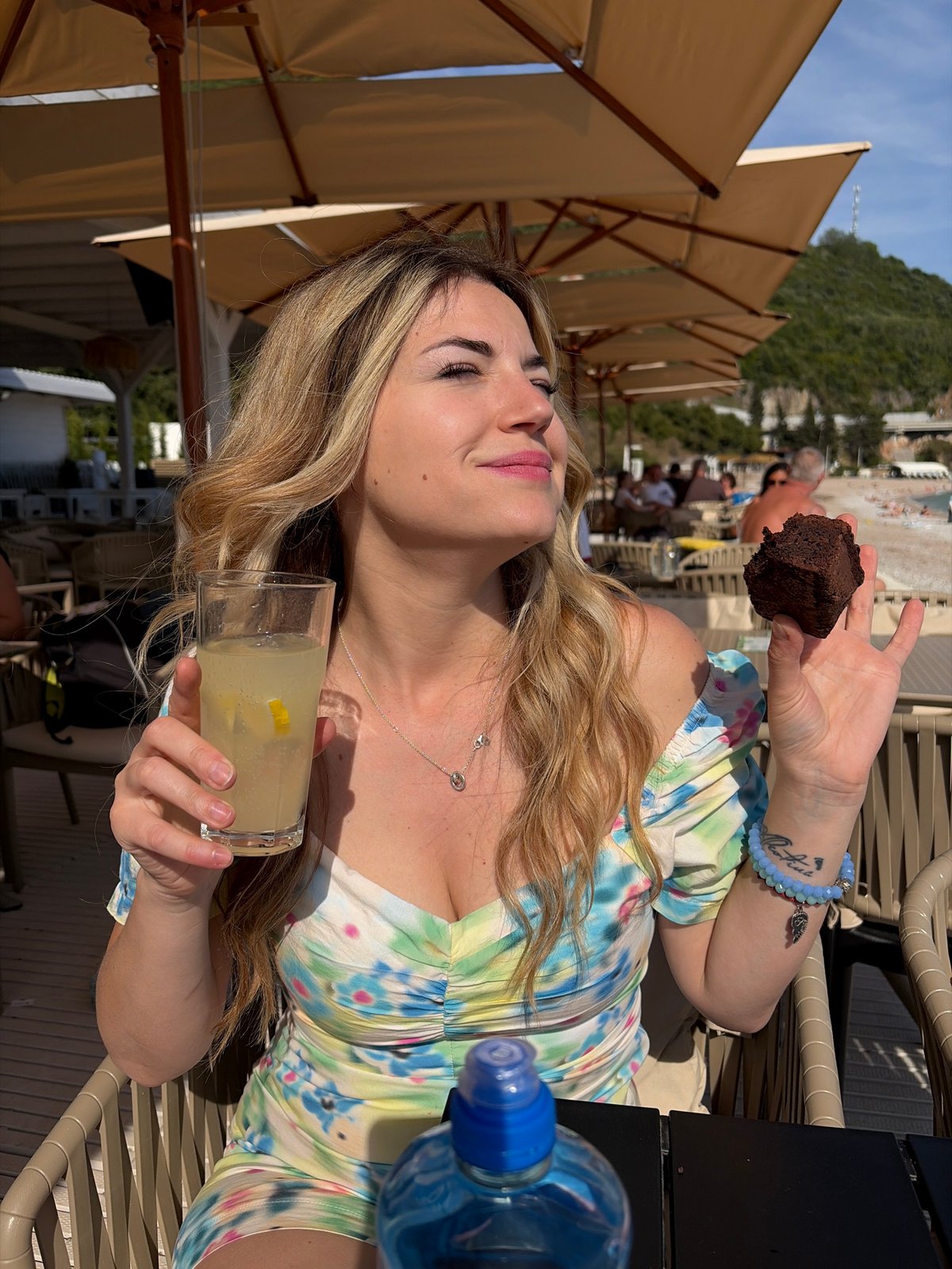 Woman enjoys sunny afternoon at beachside cafe in Budva