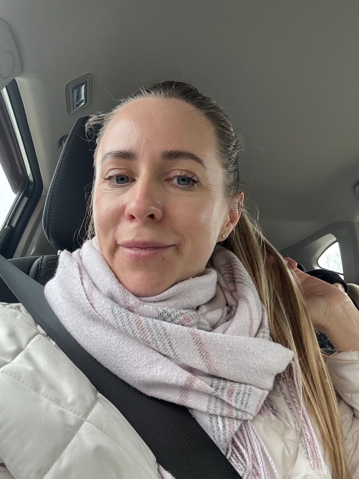Woman in car, boom lift observed in rainy Chaikovsky