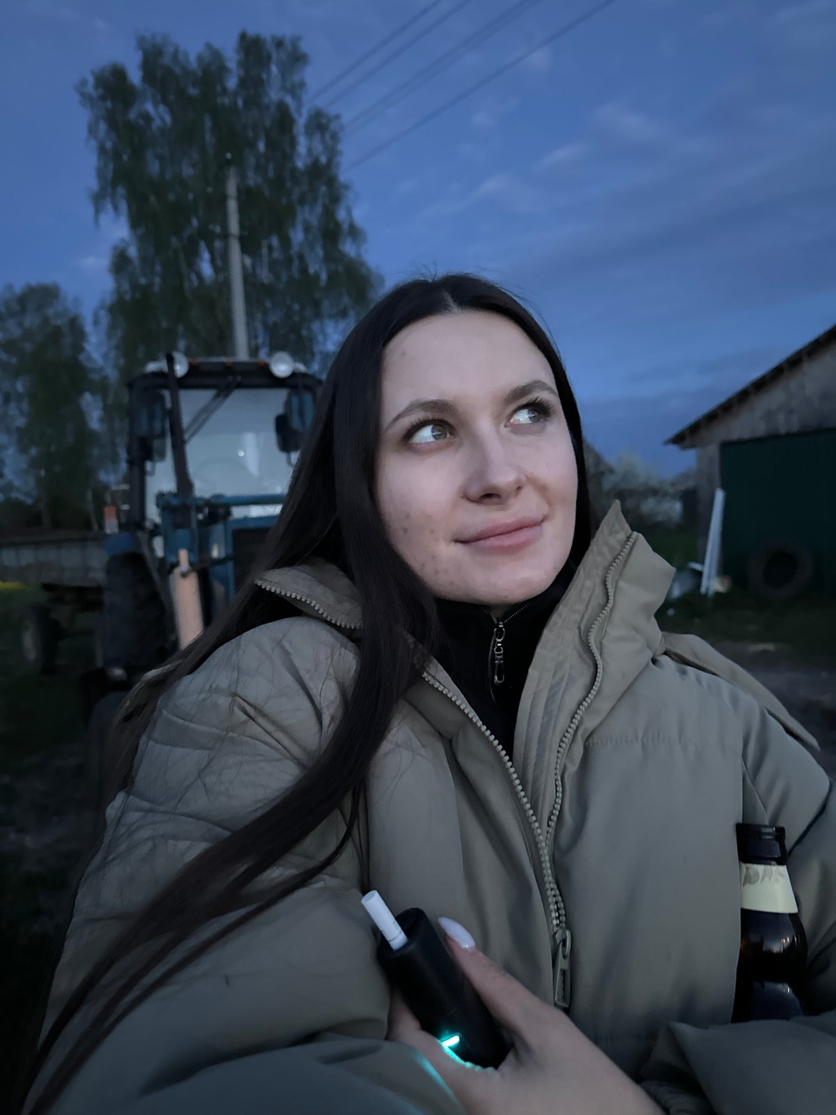 Family gathers around tractor at dusk in rural Russia