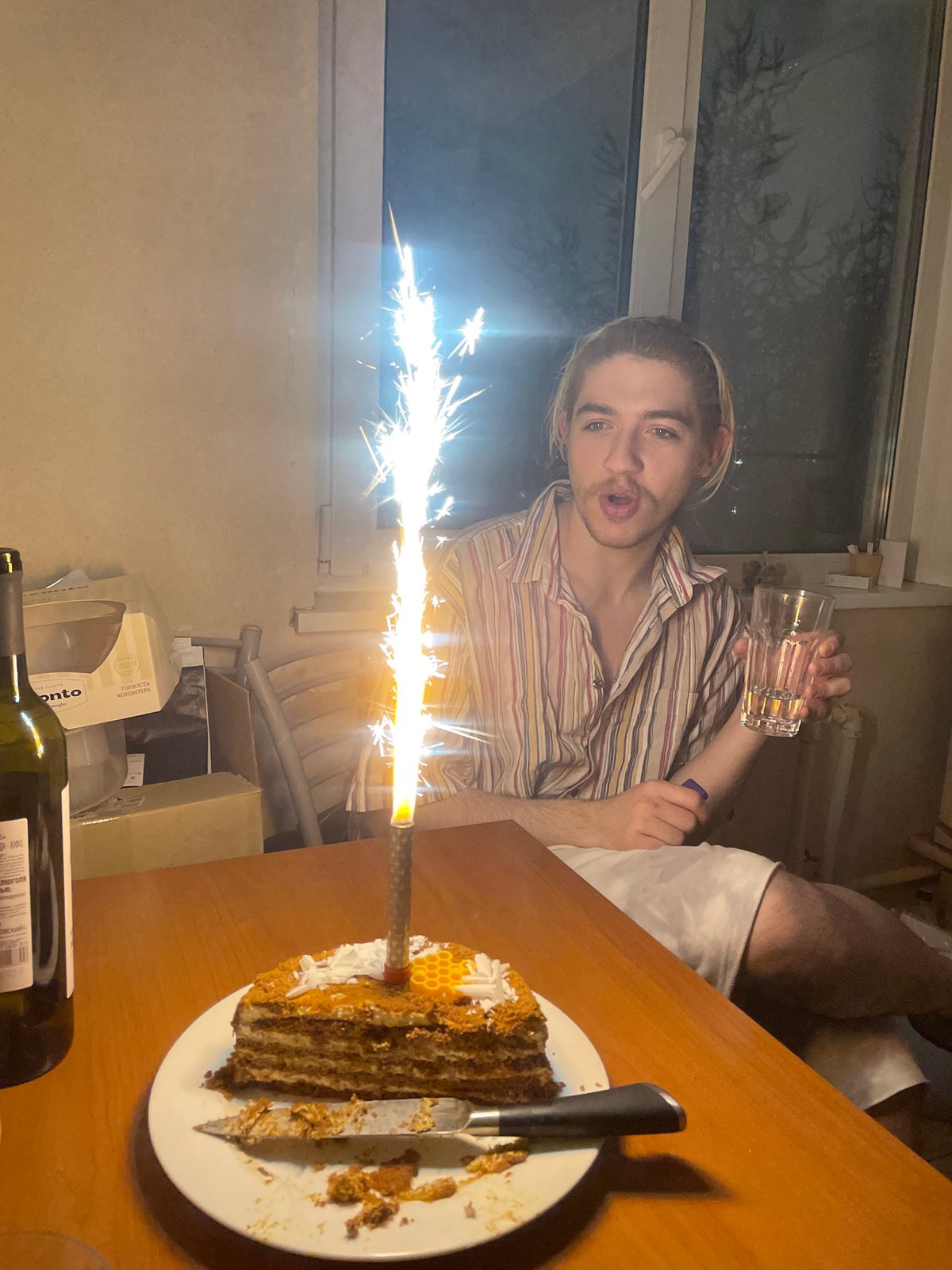 Young man celebrates with cake in Moscow indoor gathering