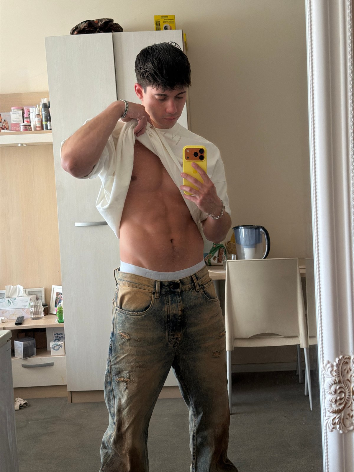 Young man takes mirror selfies with yellow phone in Sofia