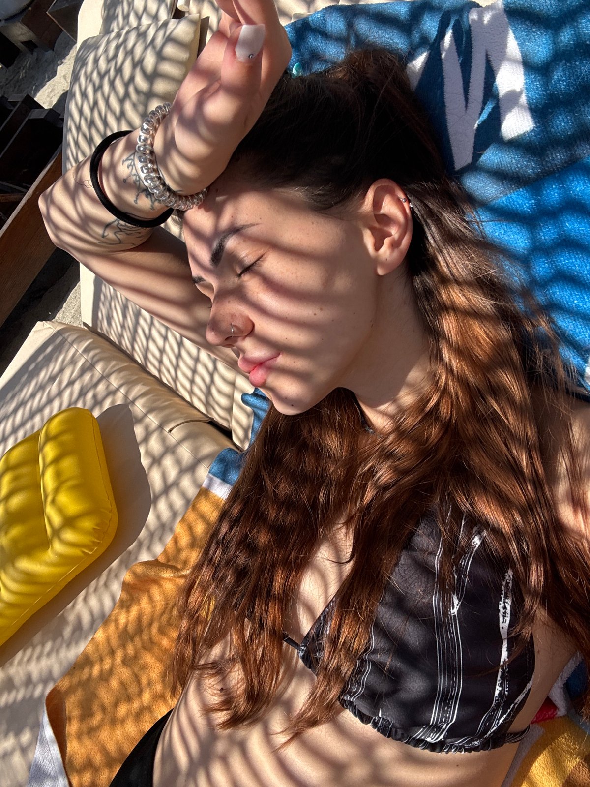 Woman enjoys beach morning with henna tattoos in Greece