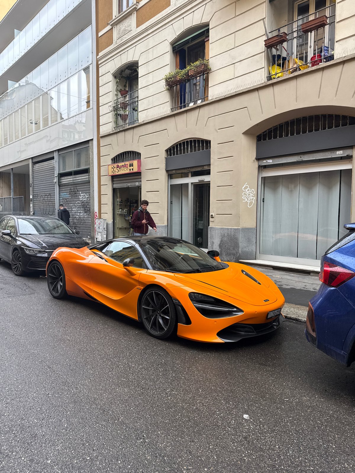 Orange McLaren spotted parked on wet Milan street