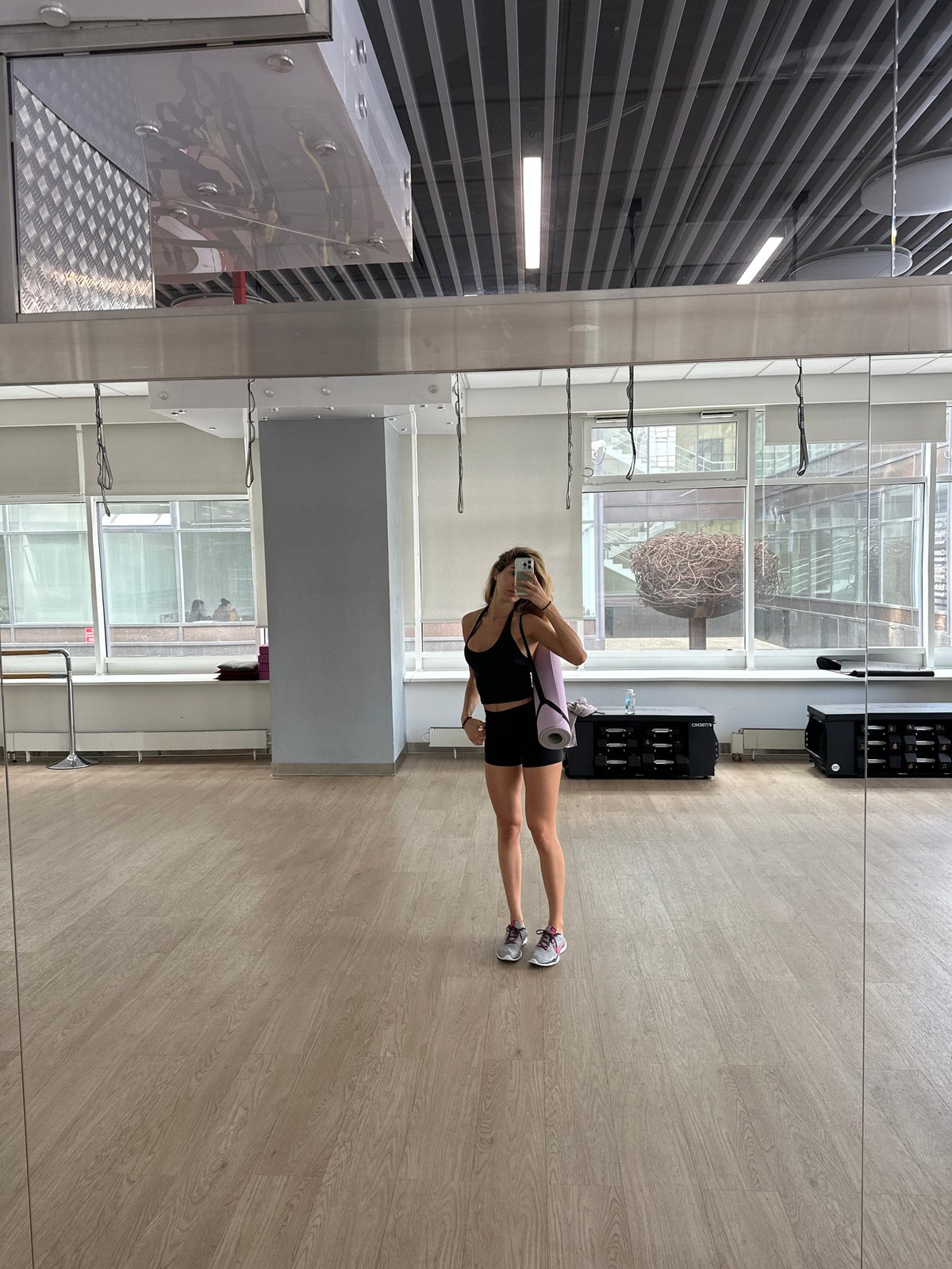 Mirror selfies at a Moscow gym, yoga mat in hand