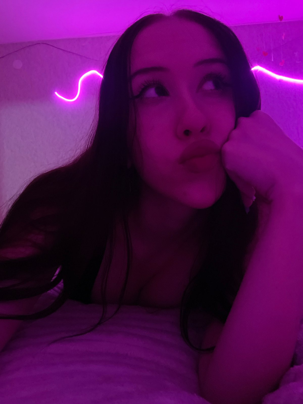 Bedroom self-portrait session under pink and purple neon lights