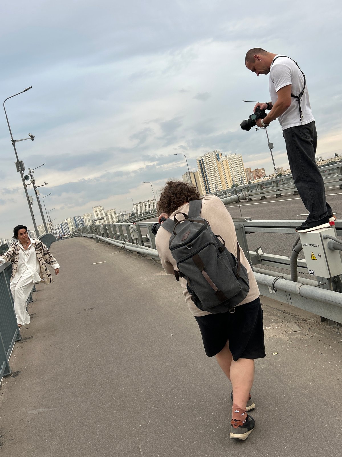 Group photographs a busy river from an urban bridge