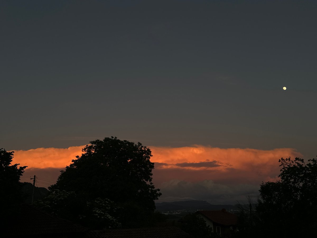 Orange cloud band illuminates evening sky over Kormiansko, Bulgaria