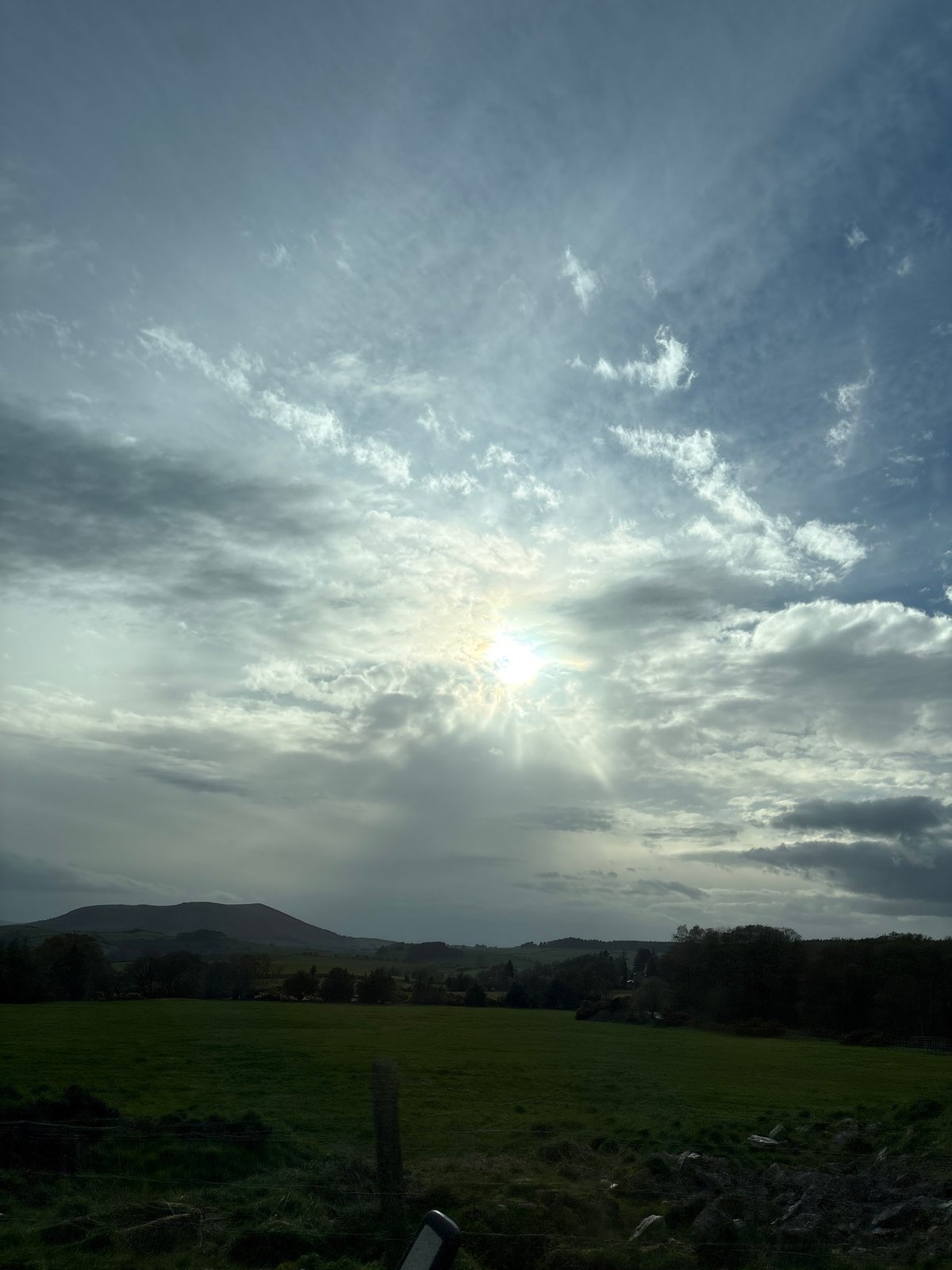 Sunlight breaks through clouds over Shelve countryside fields
