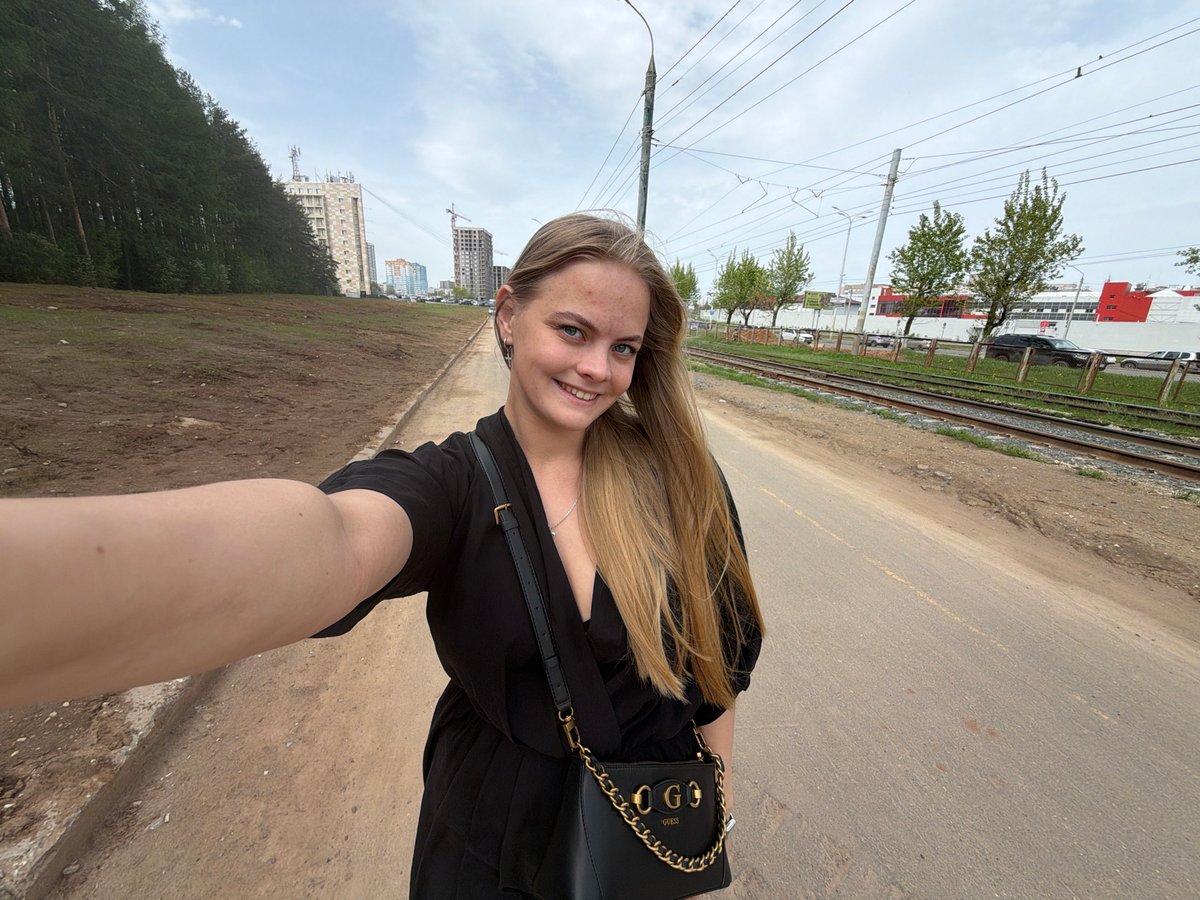 Woman takes selfies in sunny Izhevsk street