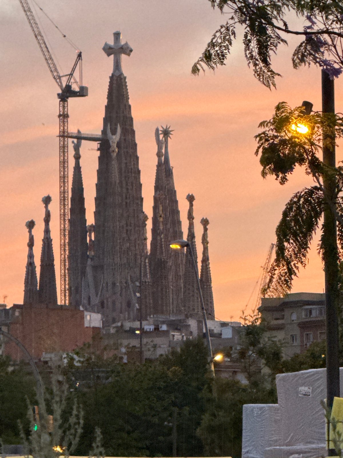 Barcelona evening stroll captures illuminated Torre Glòries at twilight