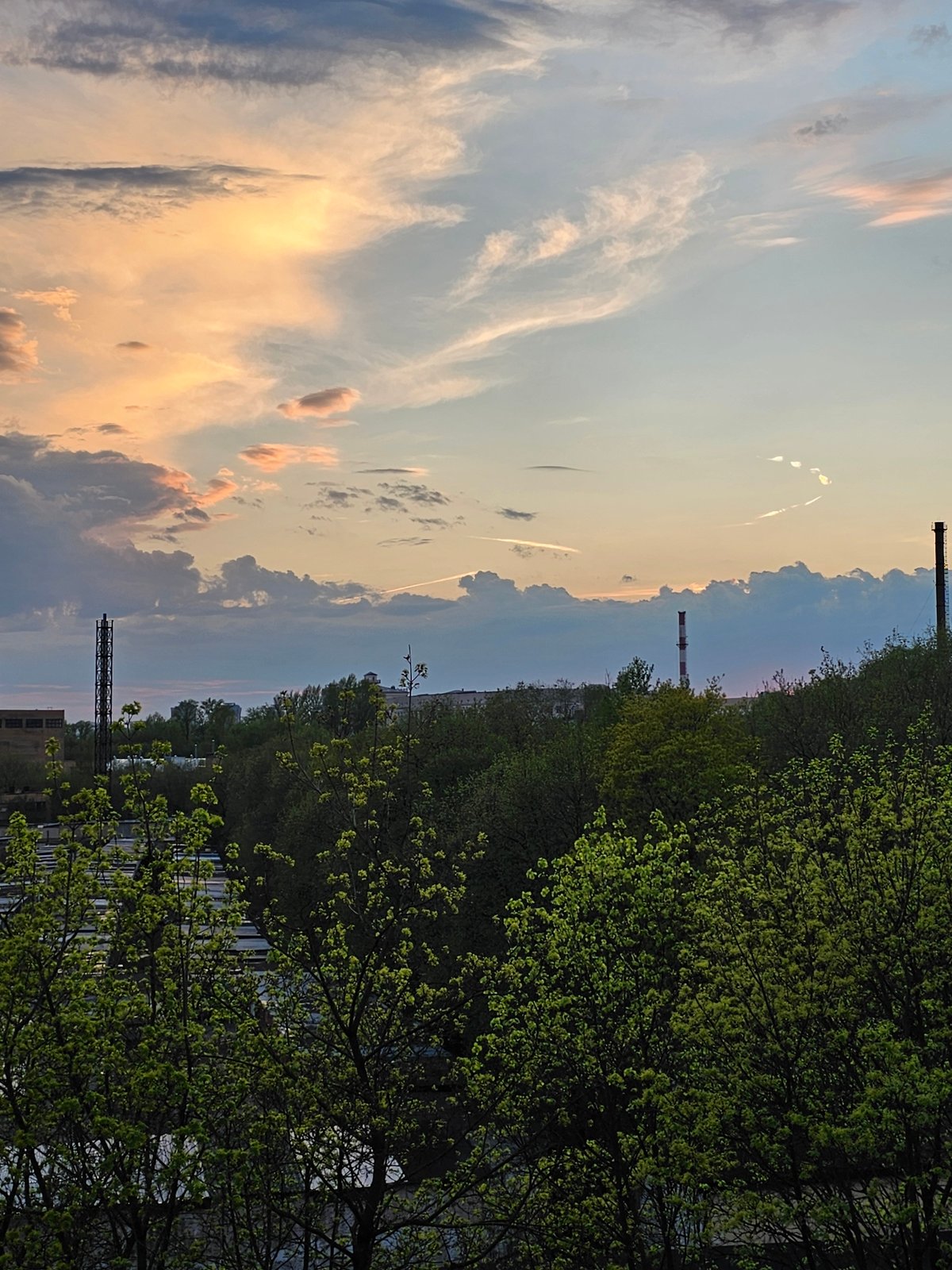 Dramatic sunset with light rays photographed over Moscow industrial area