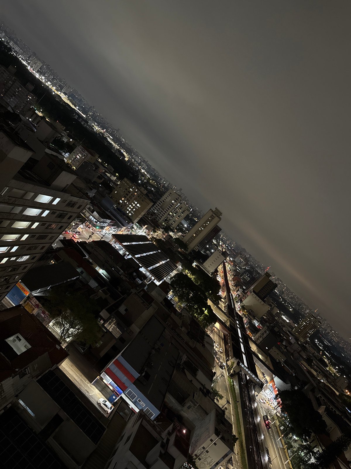 Night observer documents São Paulo cityscape and street gatherings