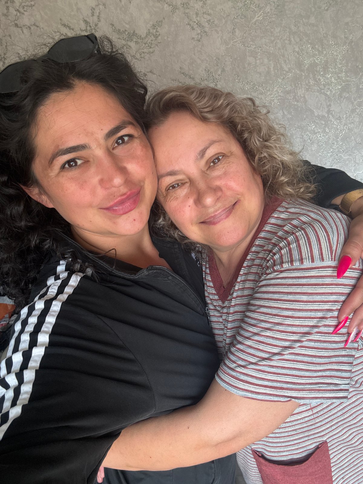 Two women rest together on couch in Кемуль