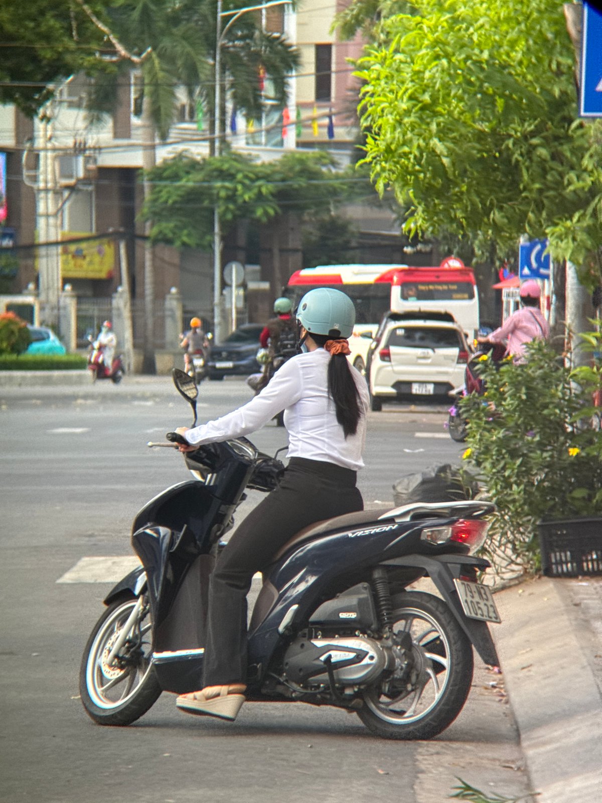 Everyday street life in Nha Trang: scooters, riders, and tree trimming