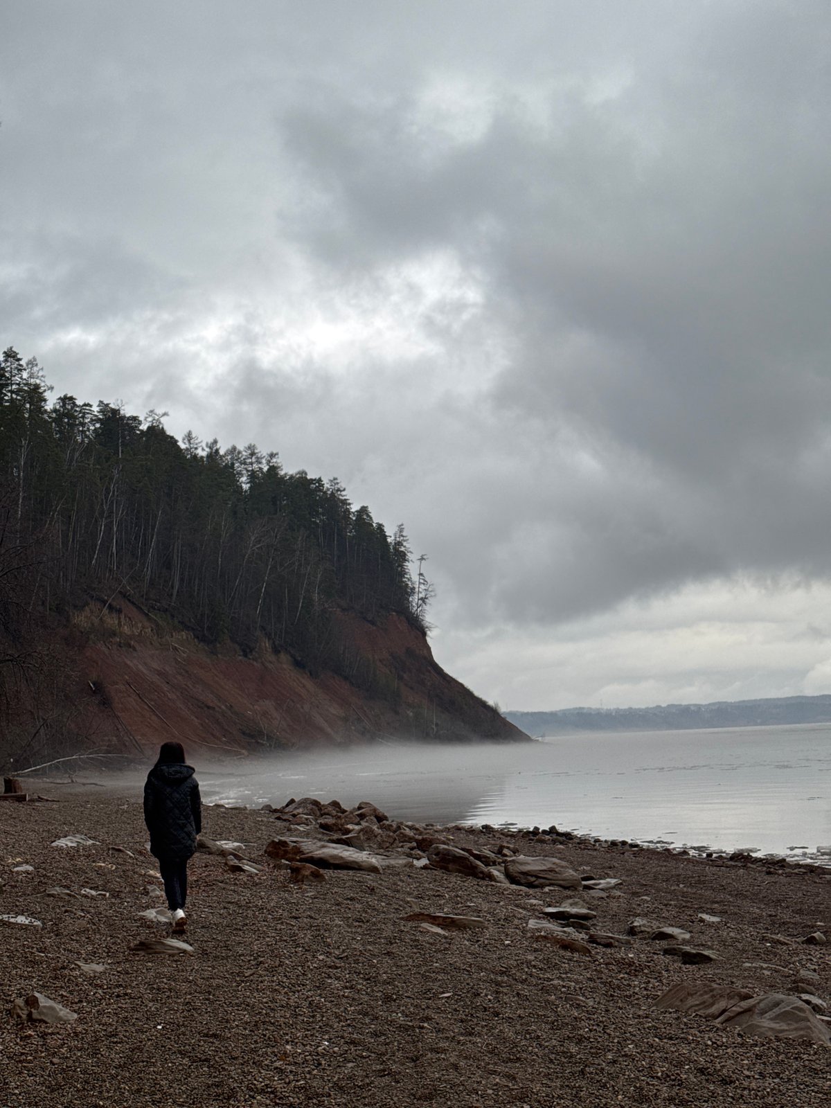 Solitary figure observed on Russian beach during cloudy afternoon