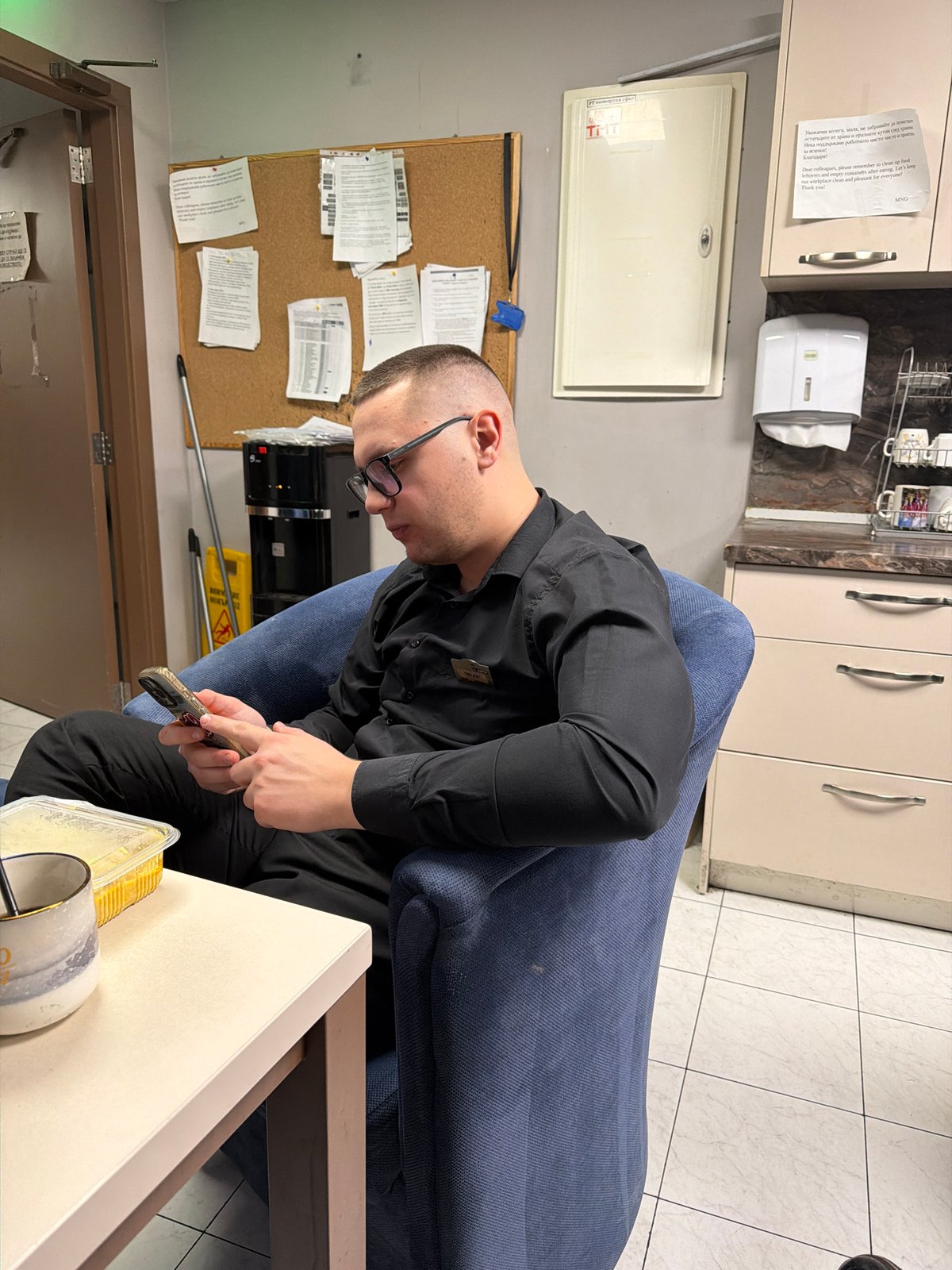 Man checks phone in armchair during late night in Sofia