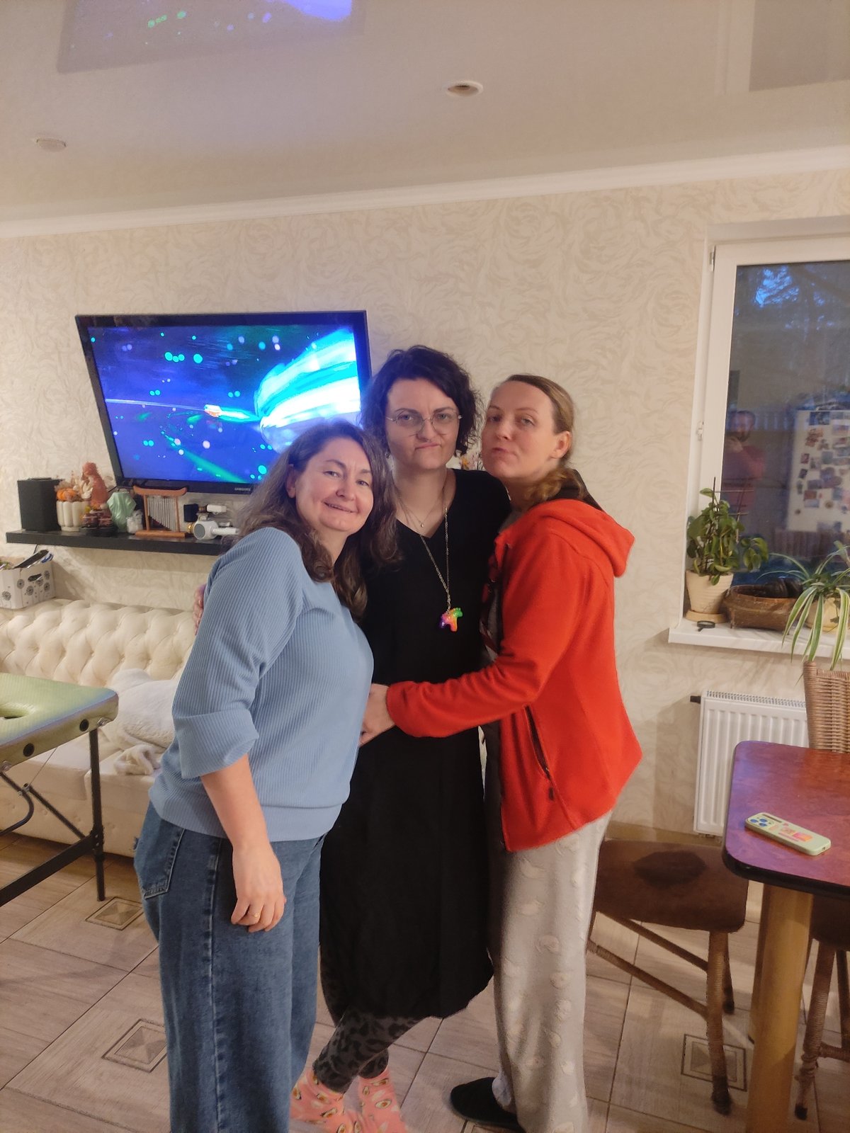 Three women pose for indoor group photo