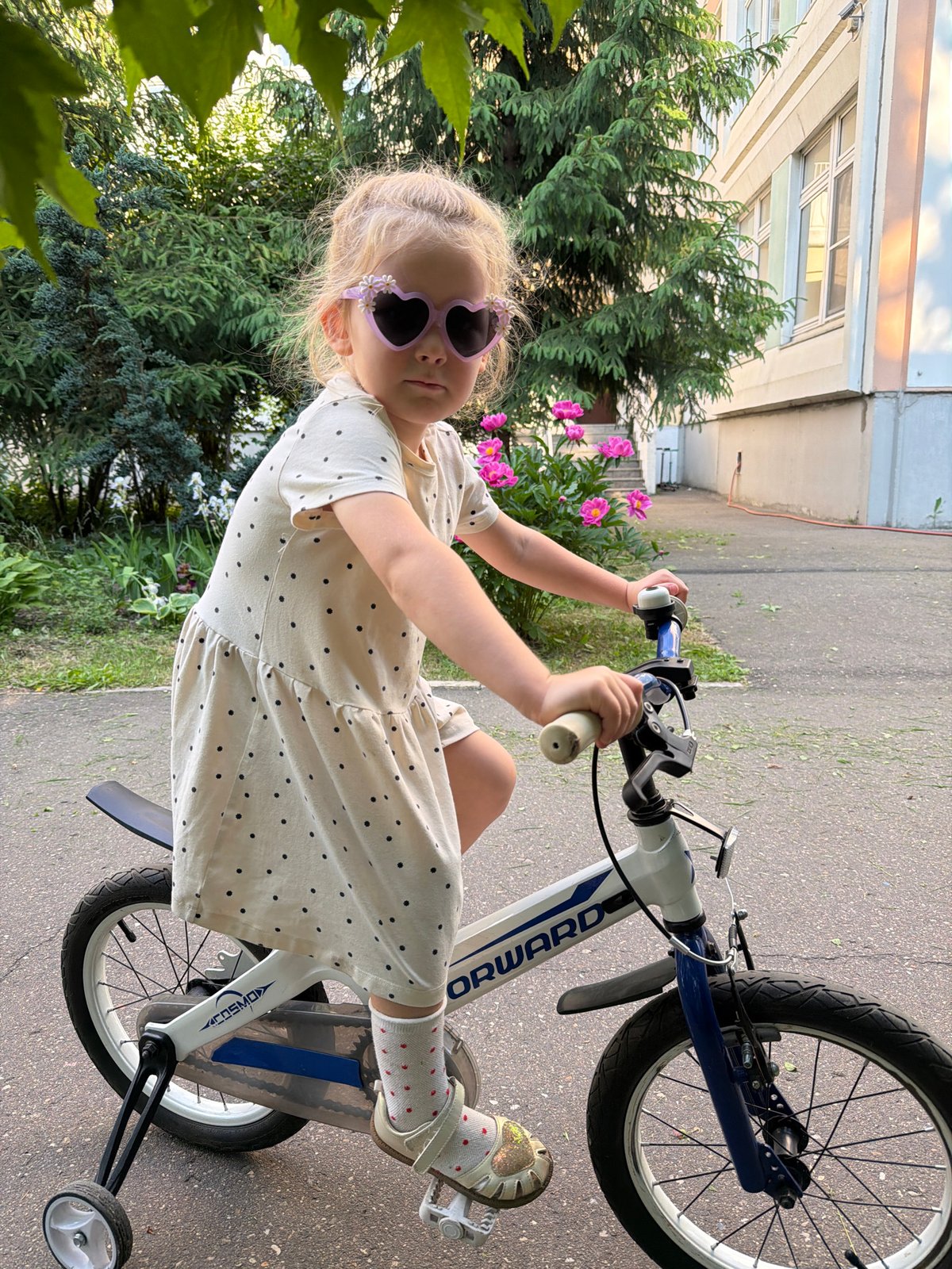 Child plays at Moscow playground amid blooming peonies