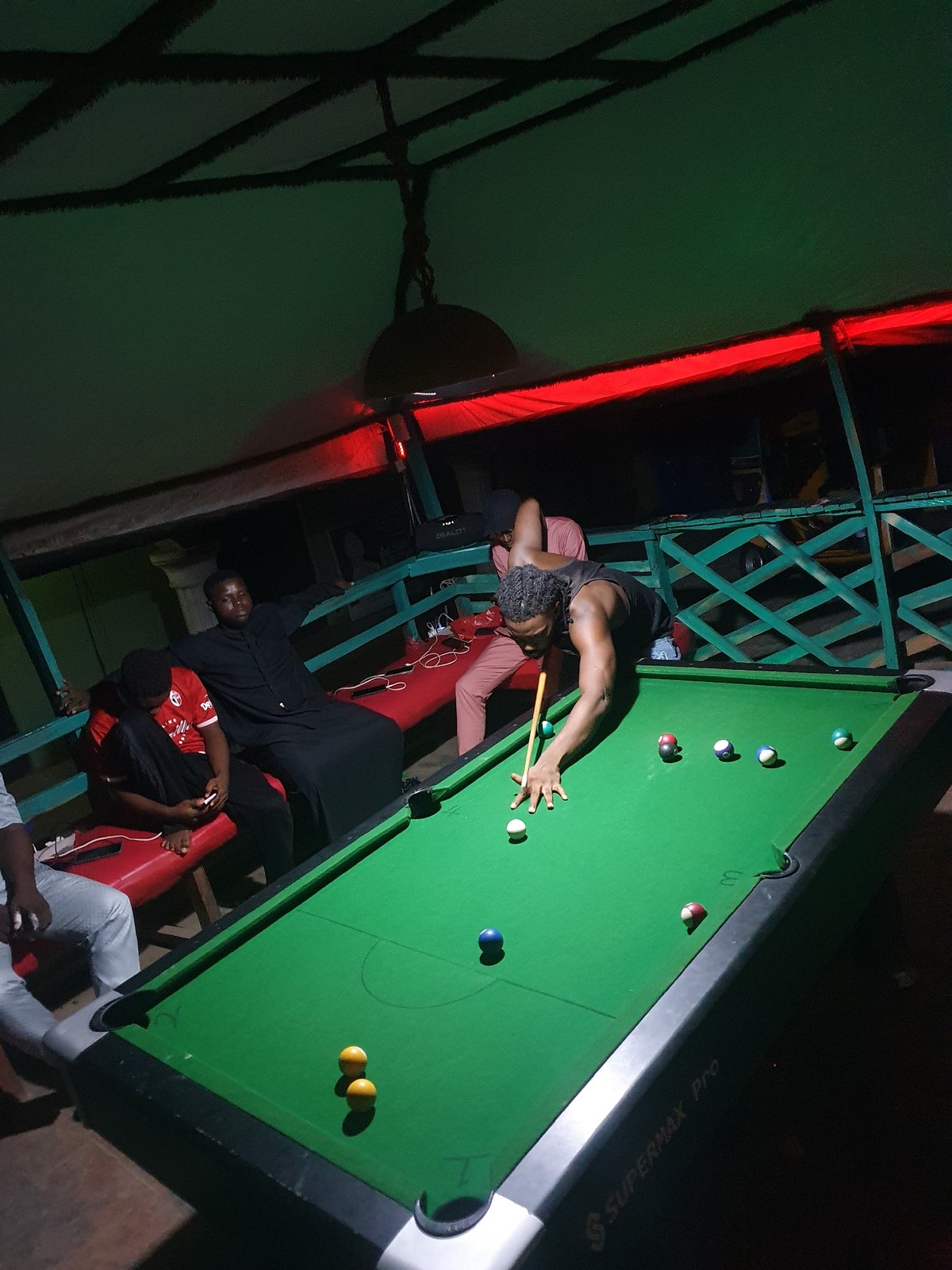 Men play casual pool game at Lokoja venue