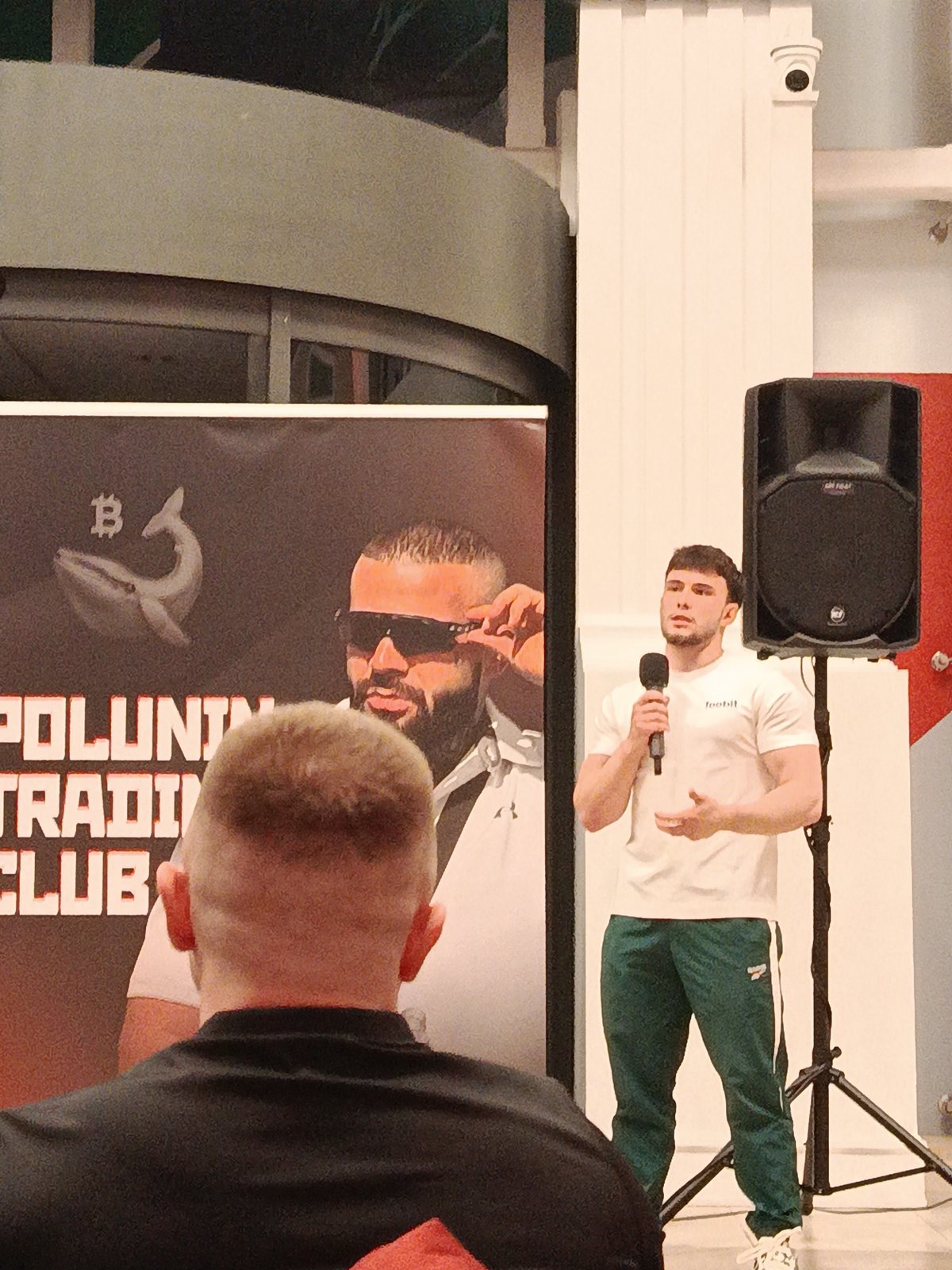 Man in football shirt speaks at cryptocurrency event
