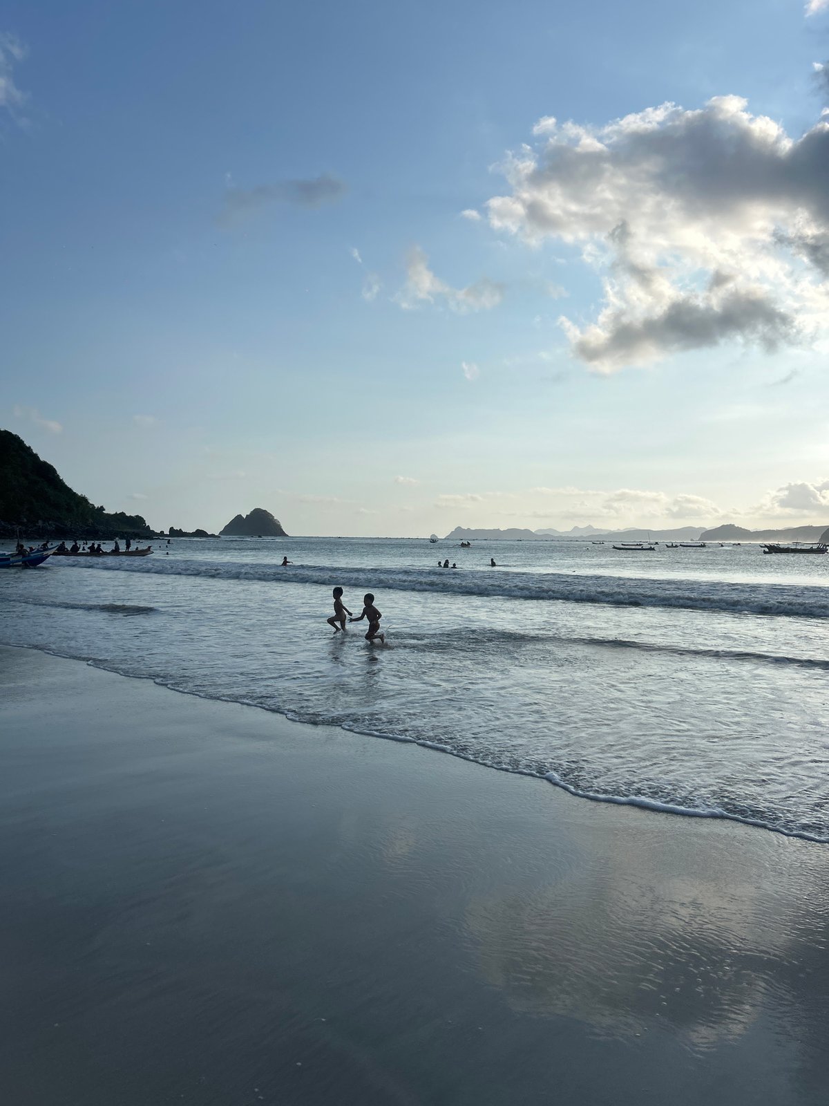 Quiet morning on Selongbelanak beach, figure wading into calm surf