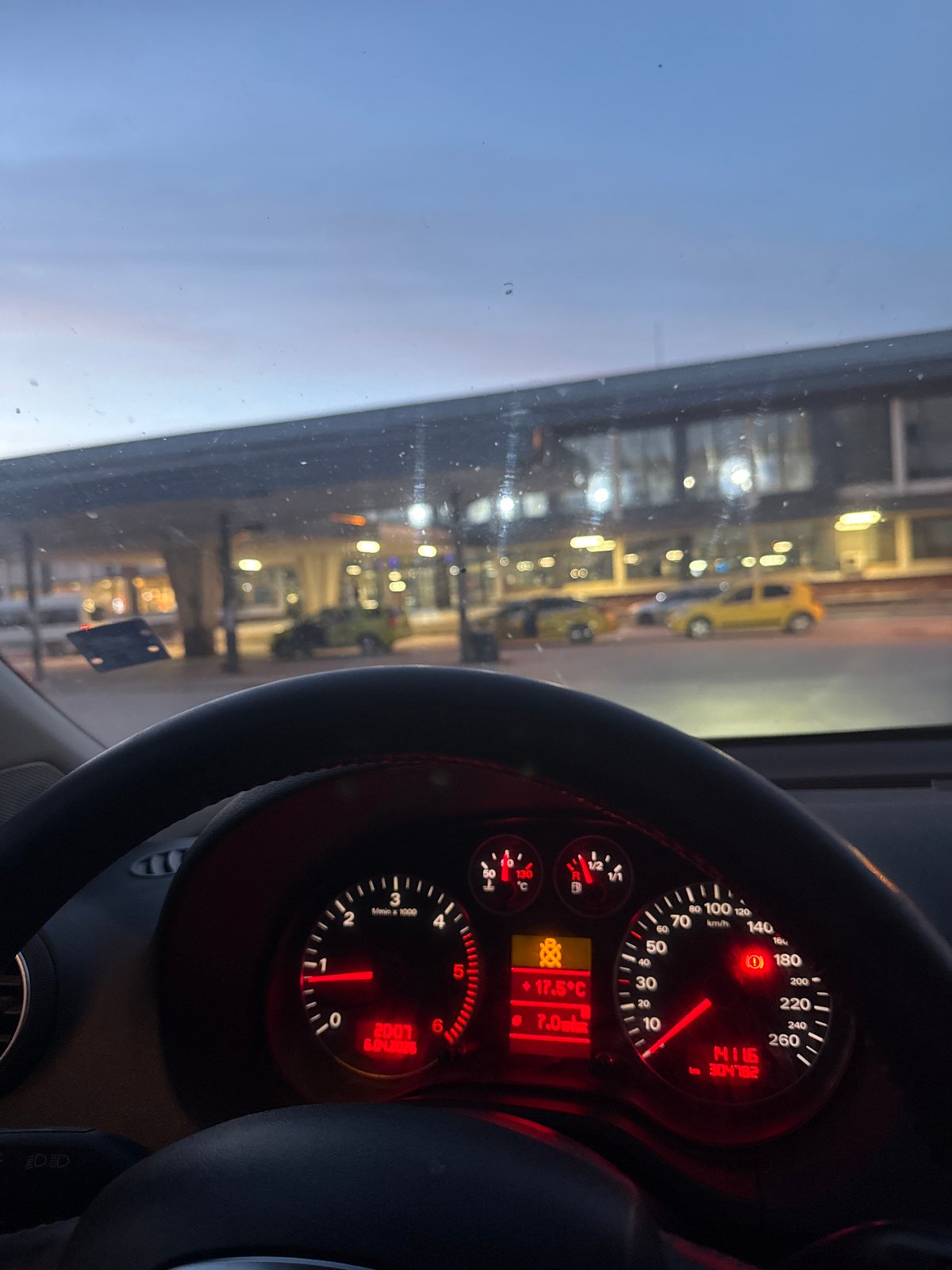 Vehicle dashboard observed while stationary, instruments illuminated