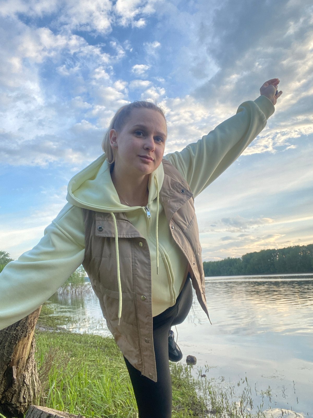 Woman poses on log near Kama River in Russia