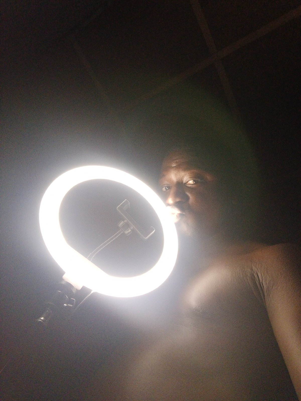 Shirtless man spotted holding ring light at unknown location